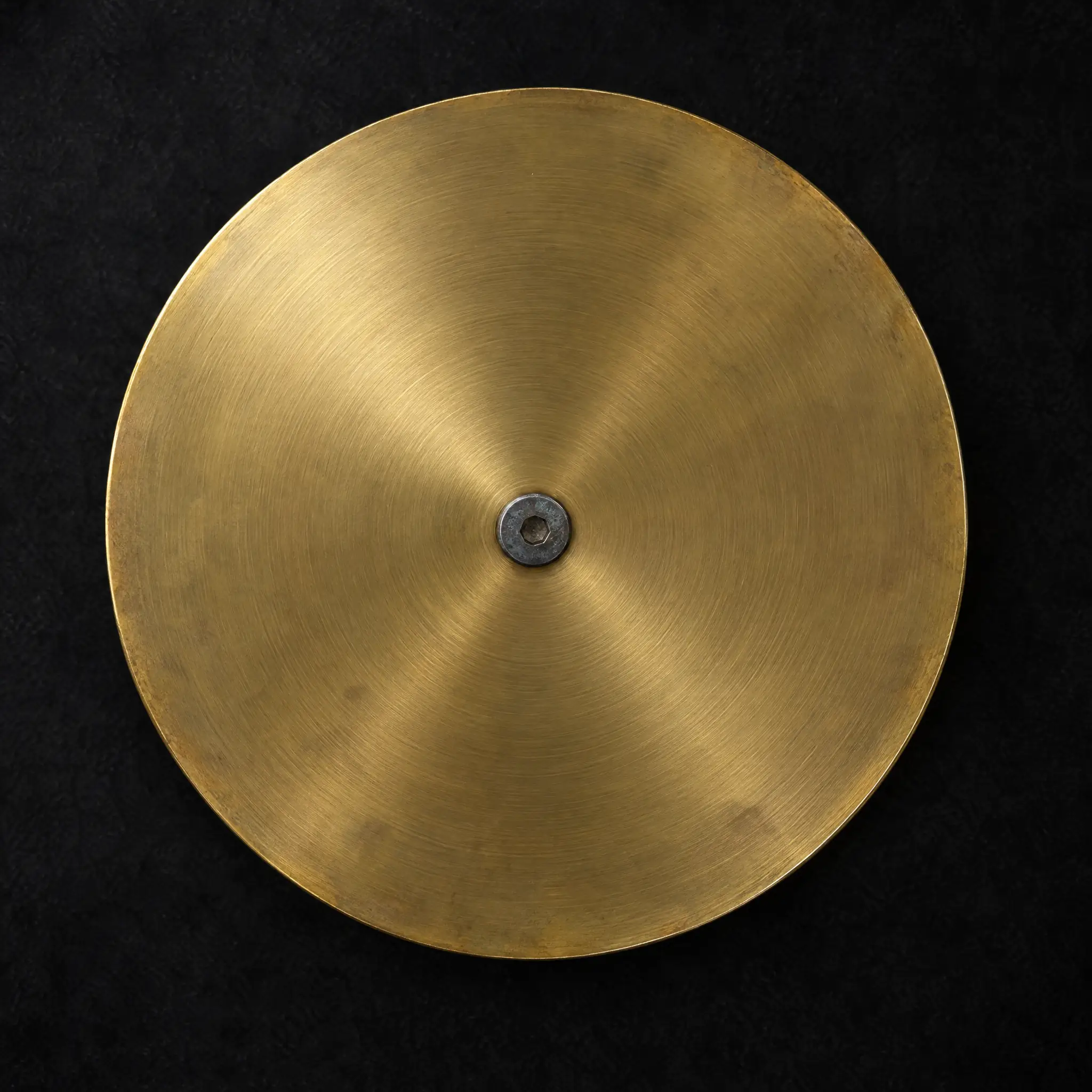 A round brass plate seen from above.
